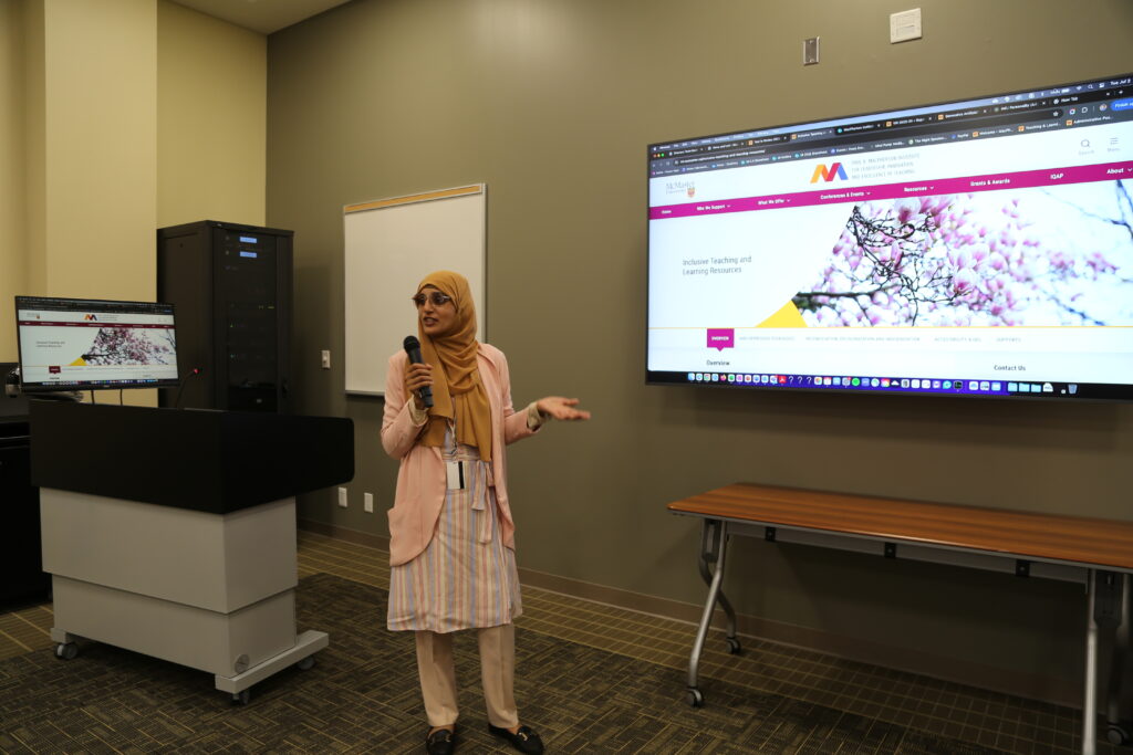 Aasiya Satia, Educational Developer Anti-Racist Pedagogies, demonstrates the new technology in the MacPherson Institute classroom. The photo shows the new classroom television monitor and computer monitor.