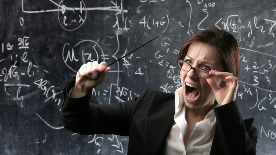 Angry teacher yelling in front of chalkboard